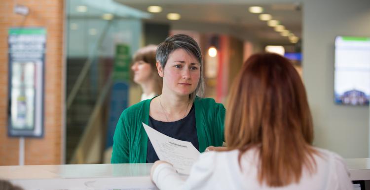Woman speaking to receptionist