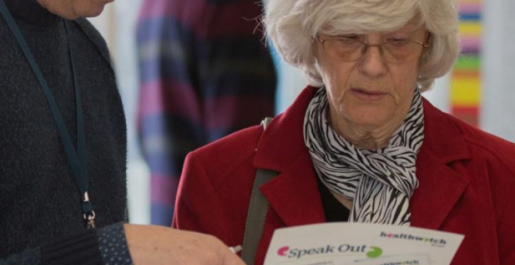 People speaking looking at leaflet