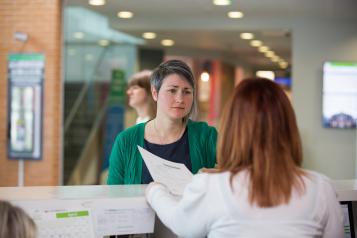 Woman speaking to receptionist 