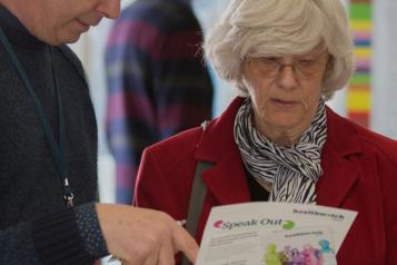 People speaking looking at leaflet