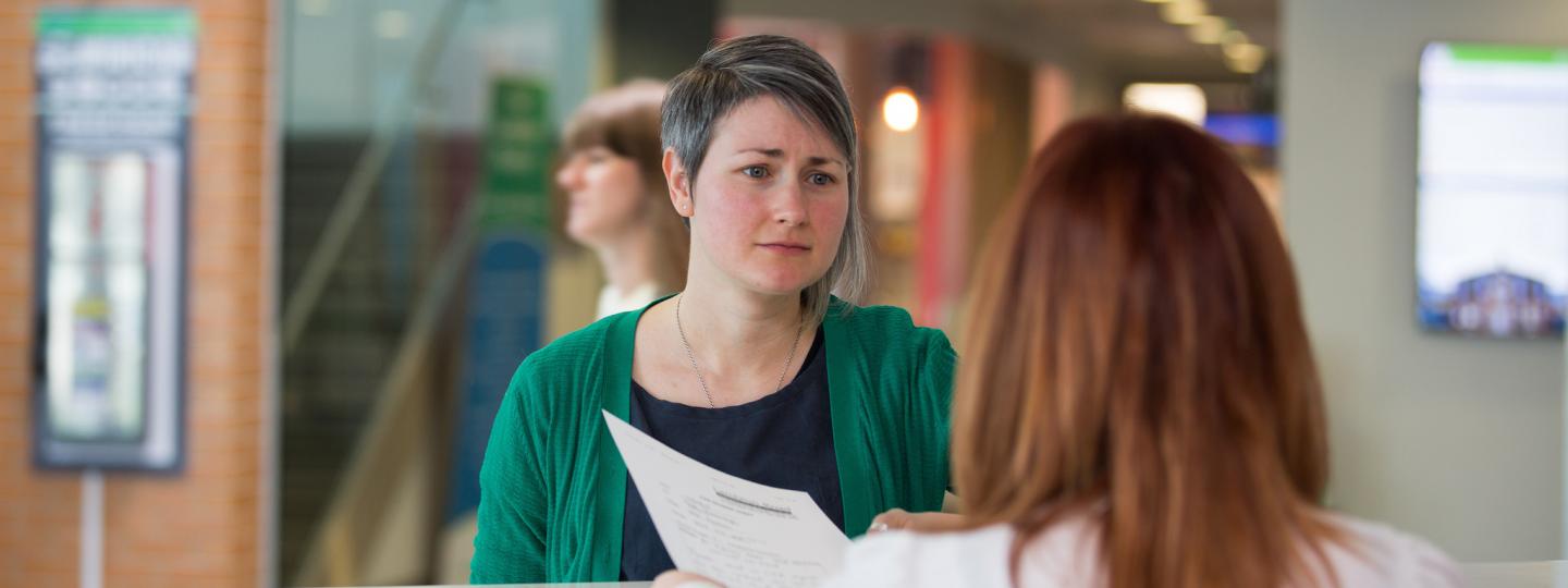 Woman speaking to receptionist 