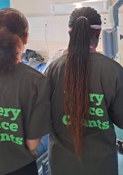 2 Young Healthwatch Volunteers speaking to a patient about their experience