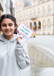 girl holding a sign saying it starts with me
