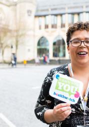 Healthwatch staff member holding an It Starts With You sign to promote the campain