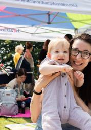 Woman sitting on a picnic blanket with her baby