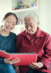 Two women reading together in a care home