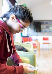 Young person using phone in waiting room